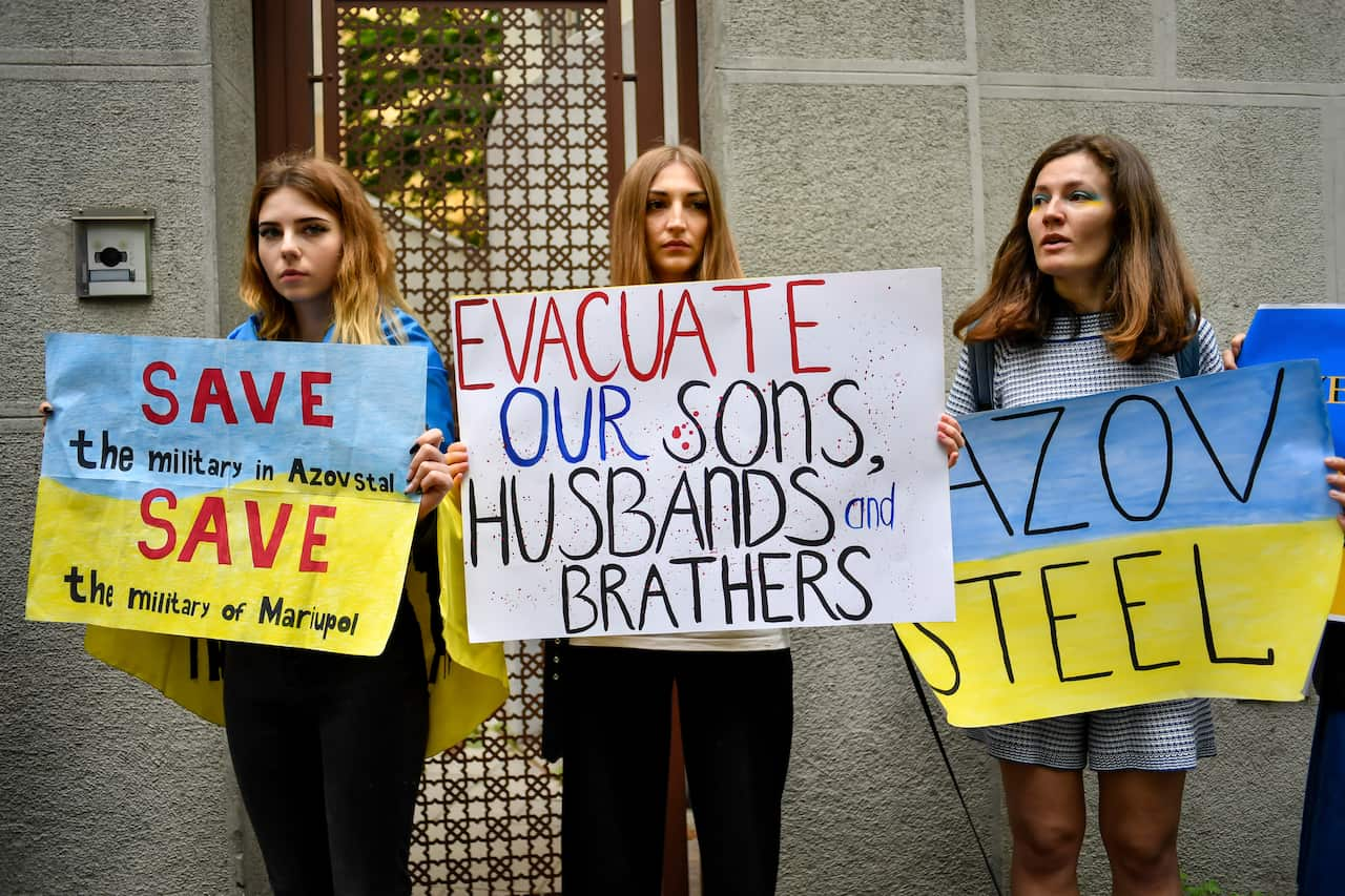 Three women holding signs.