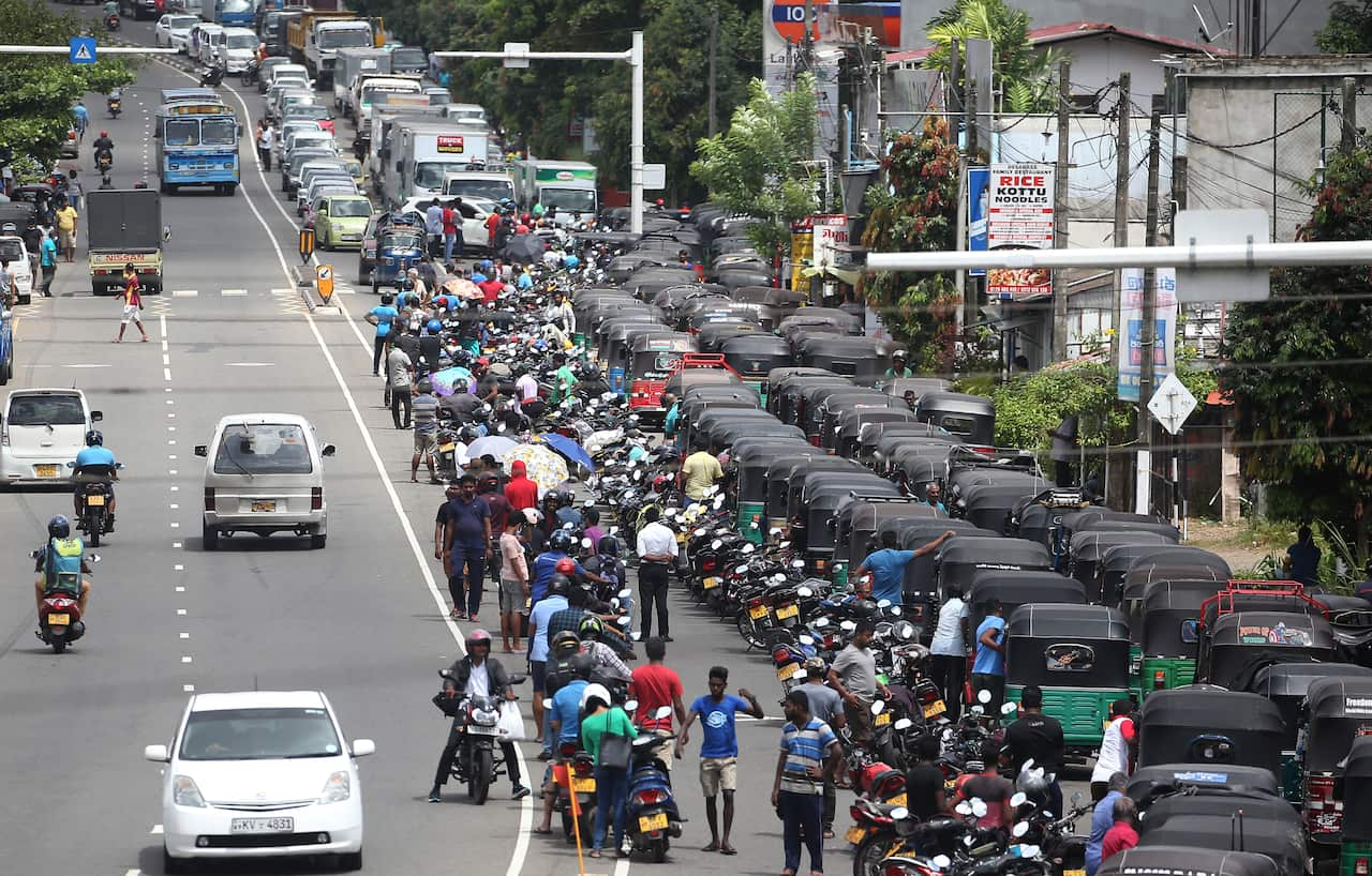 Drivers are seen in a long queue for a petrol station.