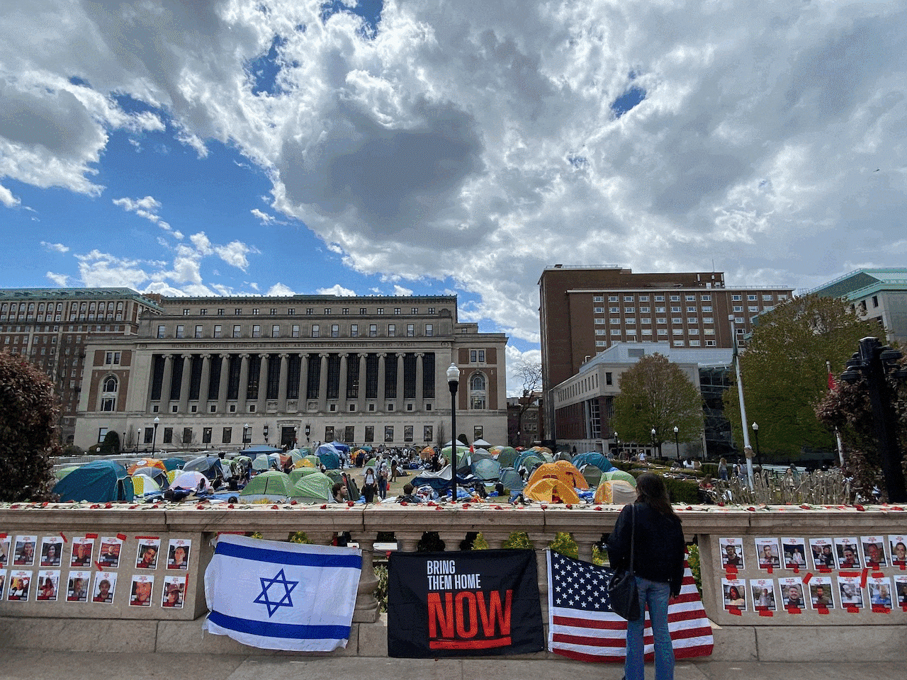 En la Universidad de Columbia, los estudiantes establecen tiendas de campaña en protesta en el césped delantero. En otra fotografía, una bandera de EE. UU., Israel y 'Traerlos a casa ahora' adorna un puente con vistas a la protesta pro-palestina. En la imagen final, una entrada del metro se ha pintado con aerosol con el texto 'Palestina libre'. La entrada está acurrucada con cinta policial.