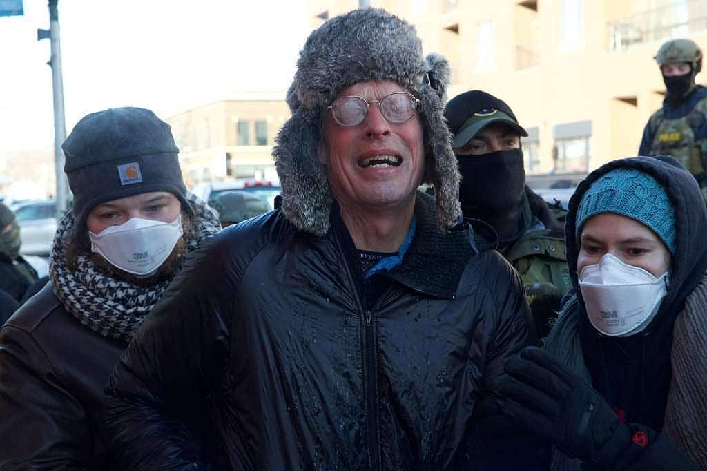 A group of people in the street look upset and scared.