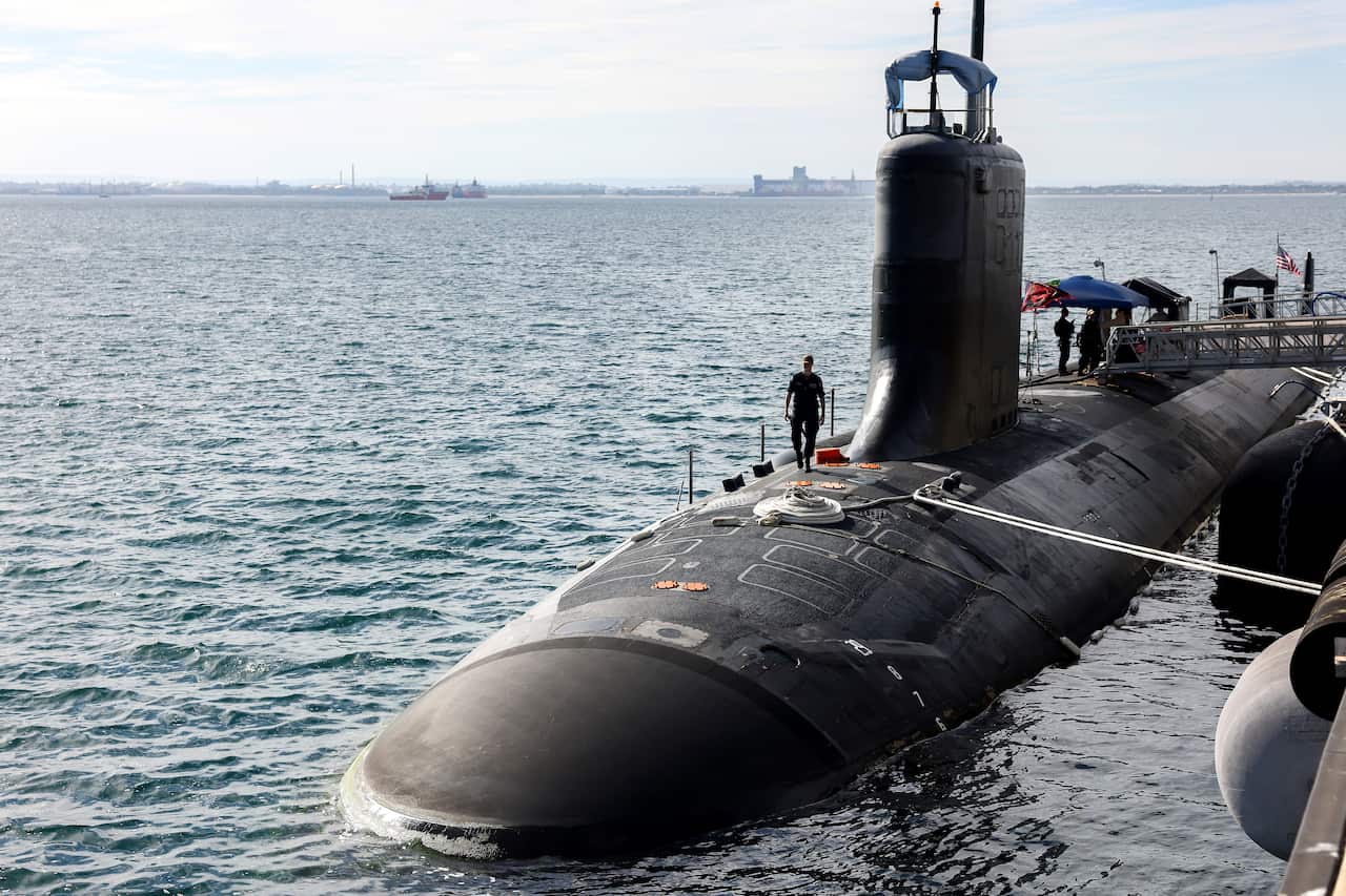 A US Navy officer walks on Virginia-class fast attack submarine.