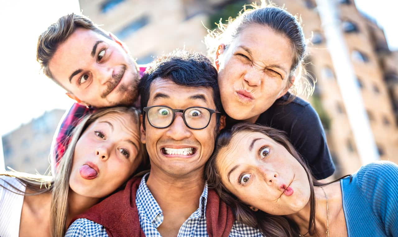 Happy guys and girls taking funny selfie out side at city - Youn