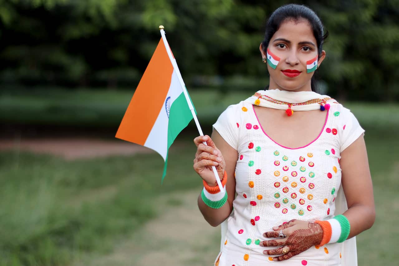 Young Indian woman holding national flag of India