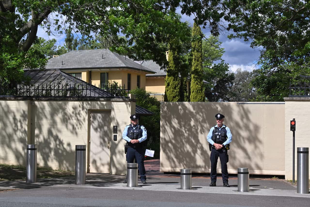 Two uniformed policemen standing guard outside a property