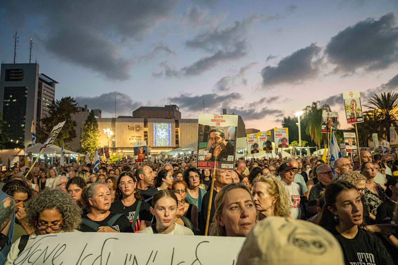 People holding up signs at a rally.