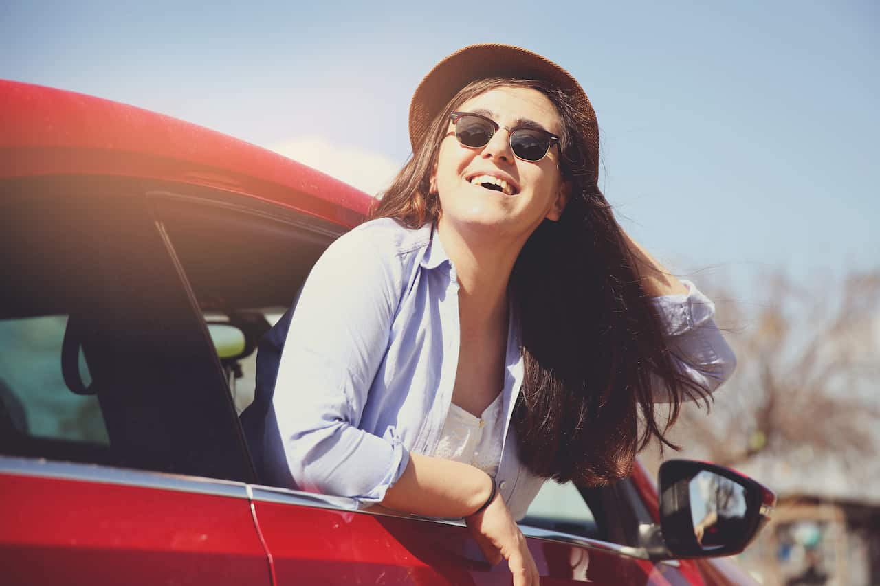 Woman with her hand out of the car window