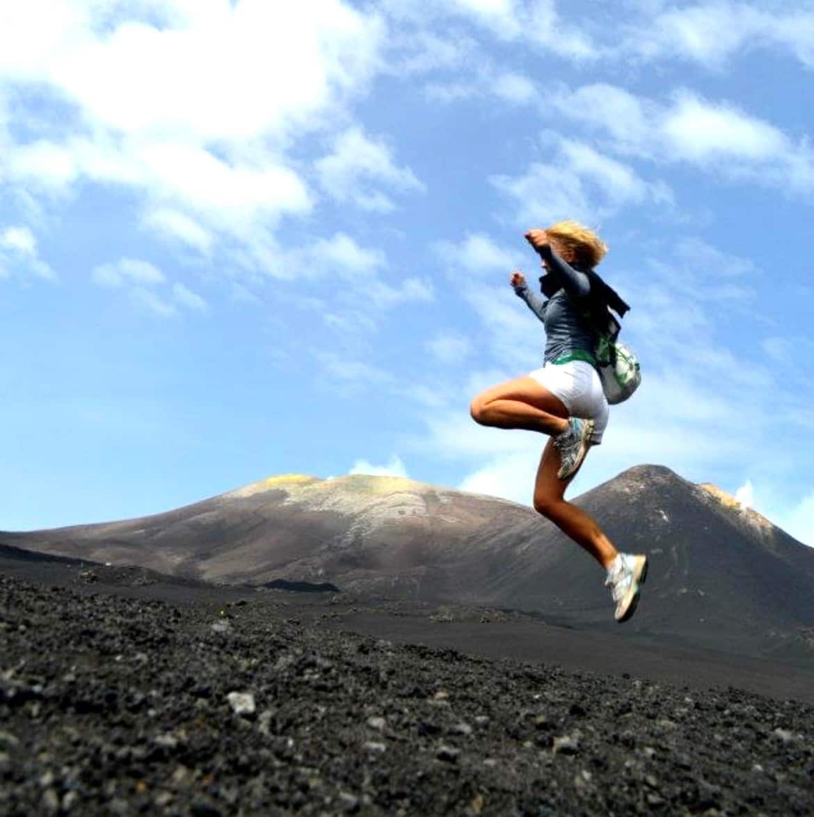 Kimberley Mitchell jumping on her walk to the summit of Mt Etna.