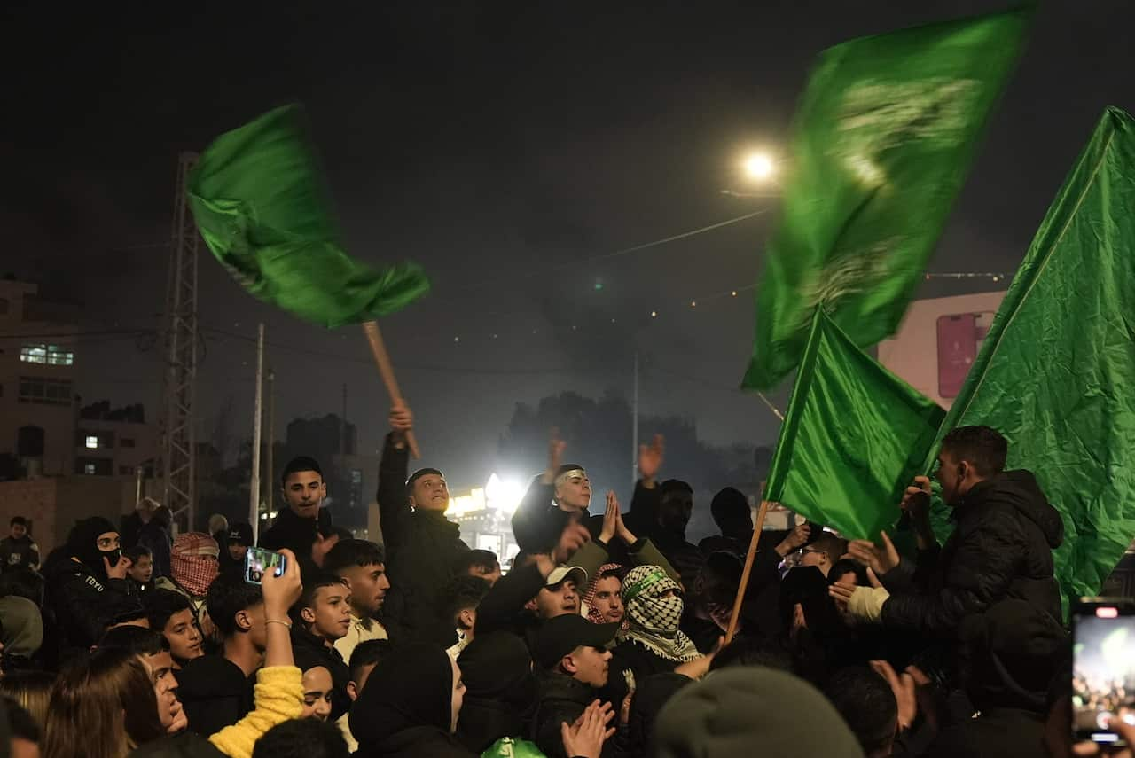 People celebrating waving green flags