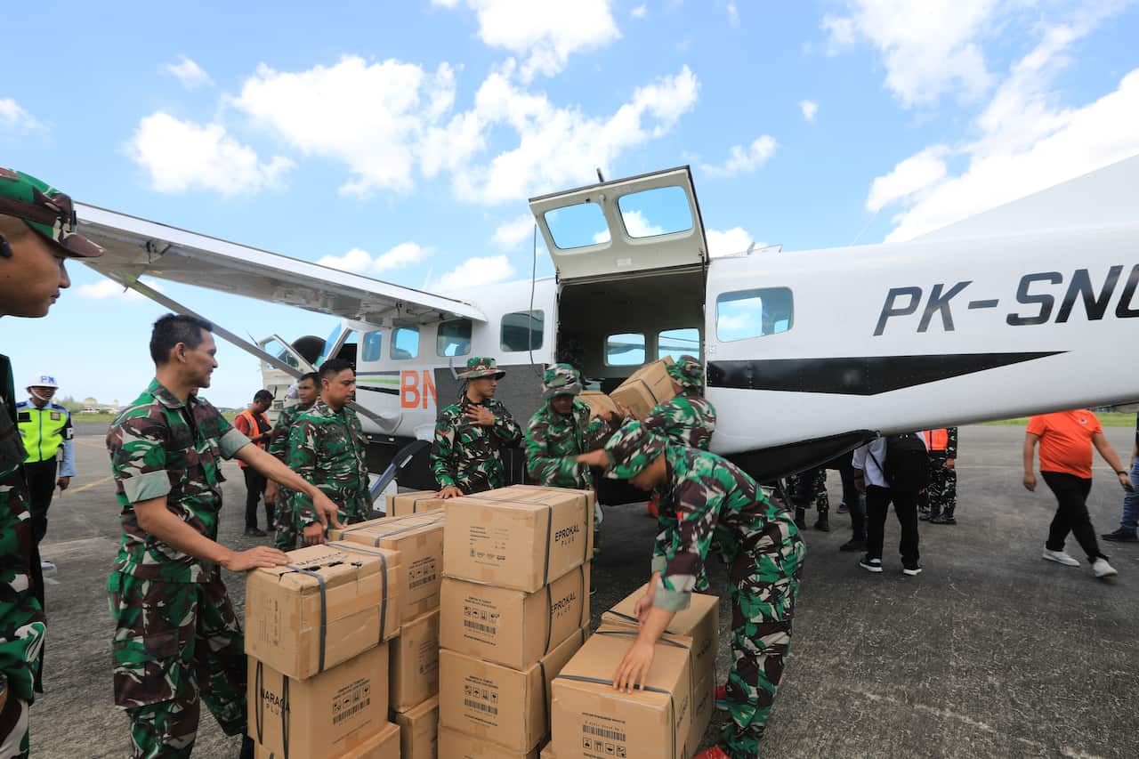 Indonesian soldiers loading aid packages onto a small plane as part of flood-relief efforts. 