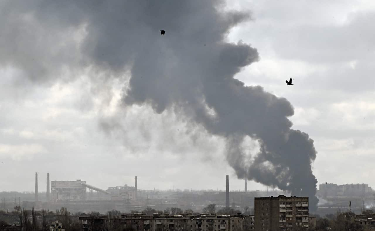 The tops of buildings and smoke on the horizon.