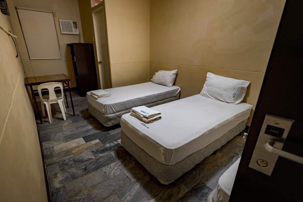 Duas camas num quarto pequeno.