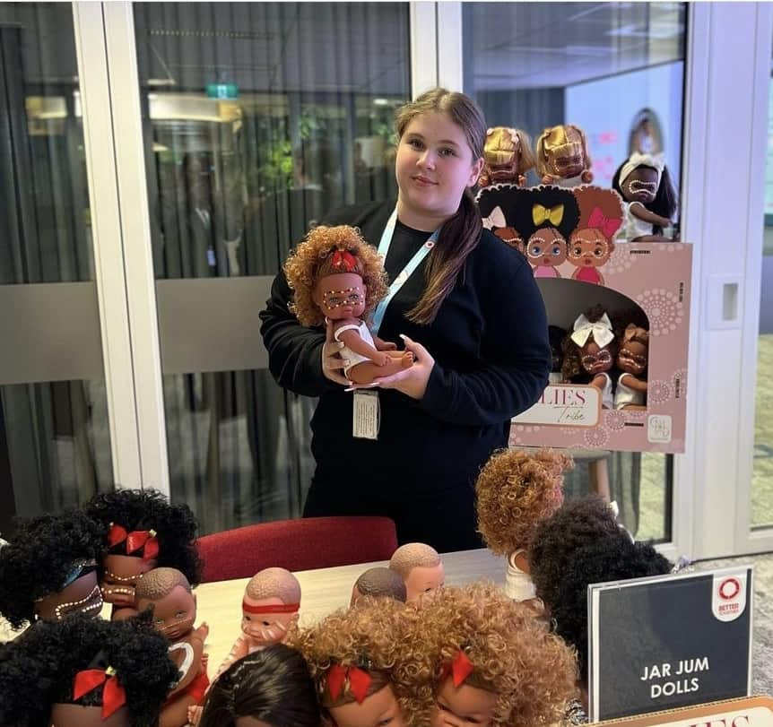 A young woman surrounded by dolls