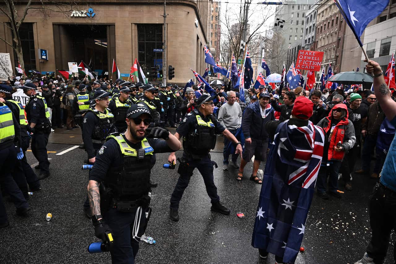 Protesters and police on a busy street.