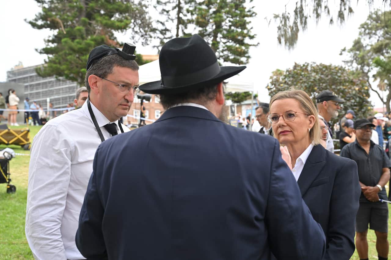 A woman talking to two men.