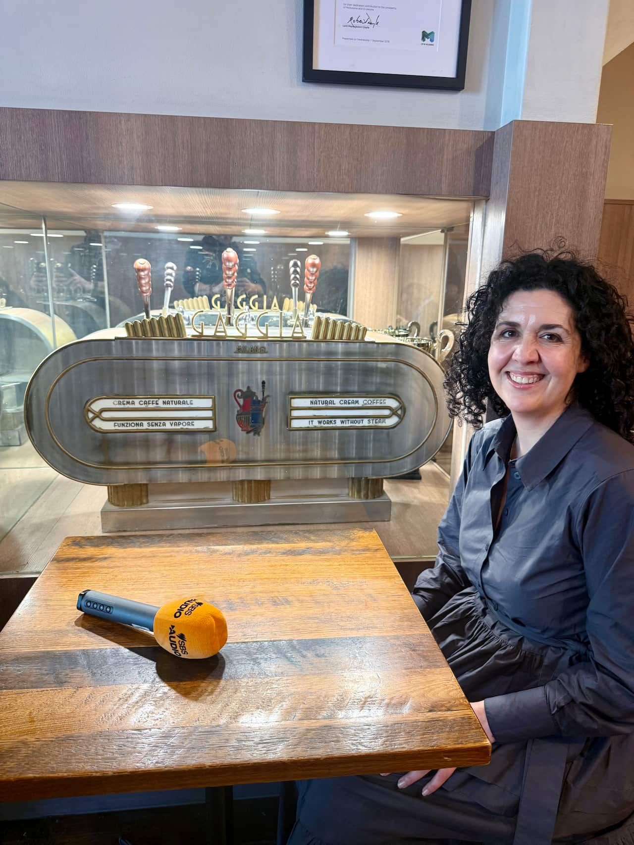 Tania Cammarano di fronte ad uno storico modello di macchina da caffè Gaggia.