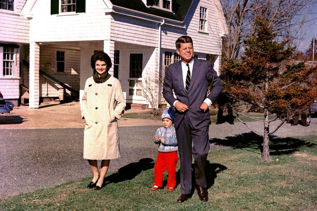 A man and a woman walking with their young daughter.