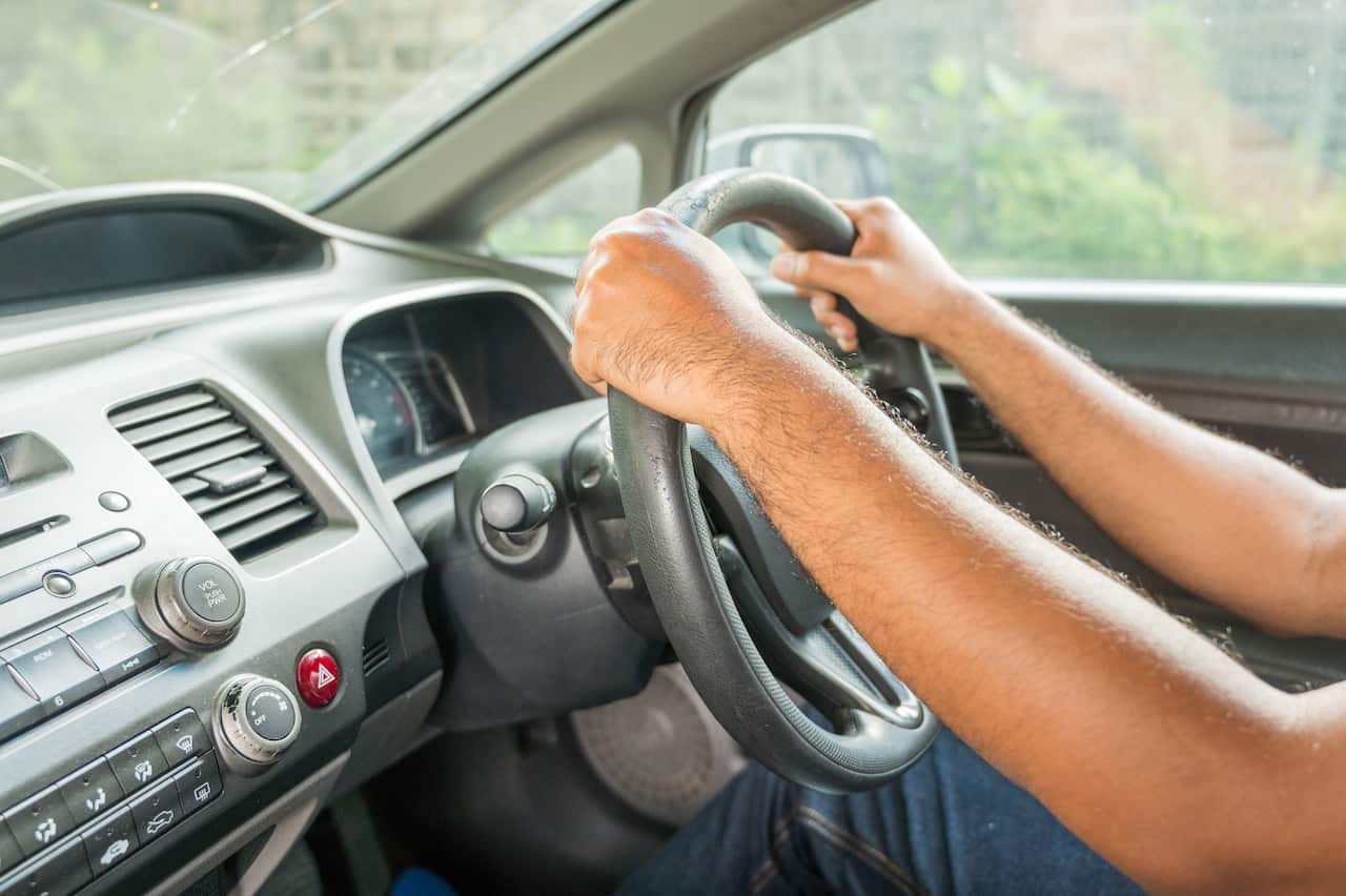 Hands male driving in his car.