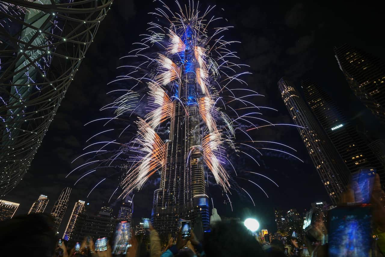 Fireworks sprouting out the sides of a tall building.