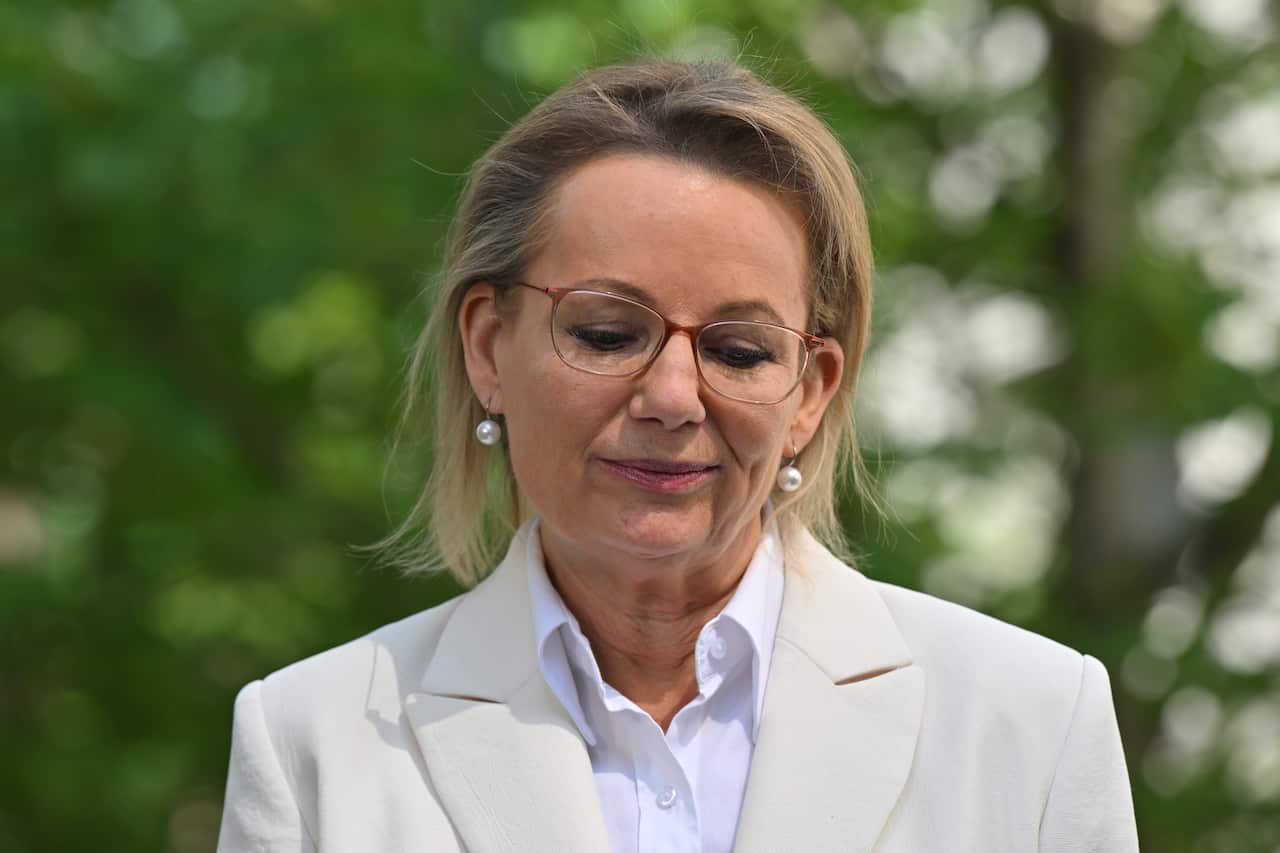 A middle-aged white woman looking down cast