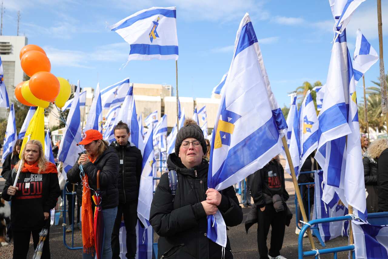 People stand together outside among Israeli flags