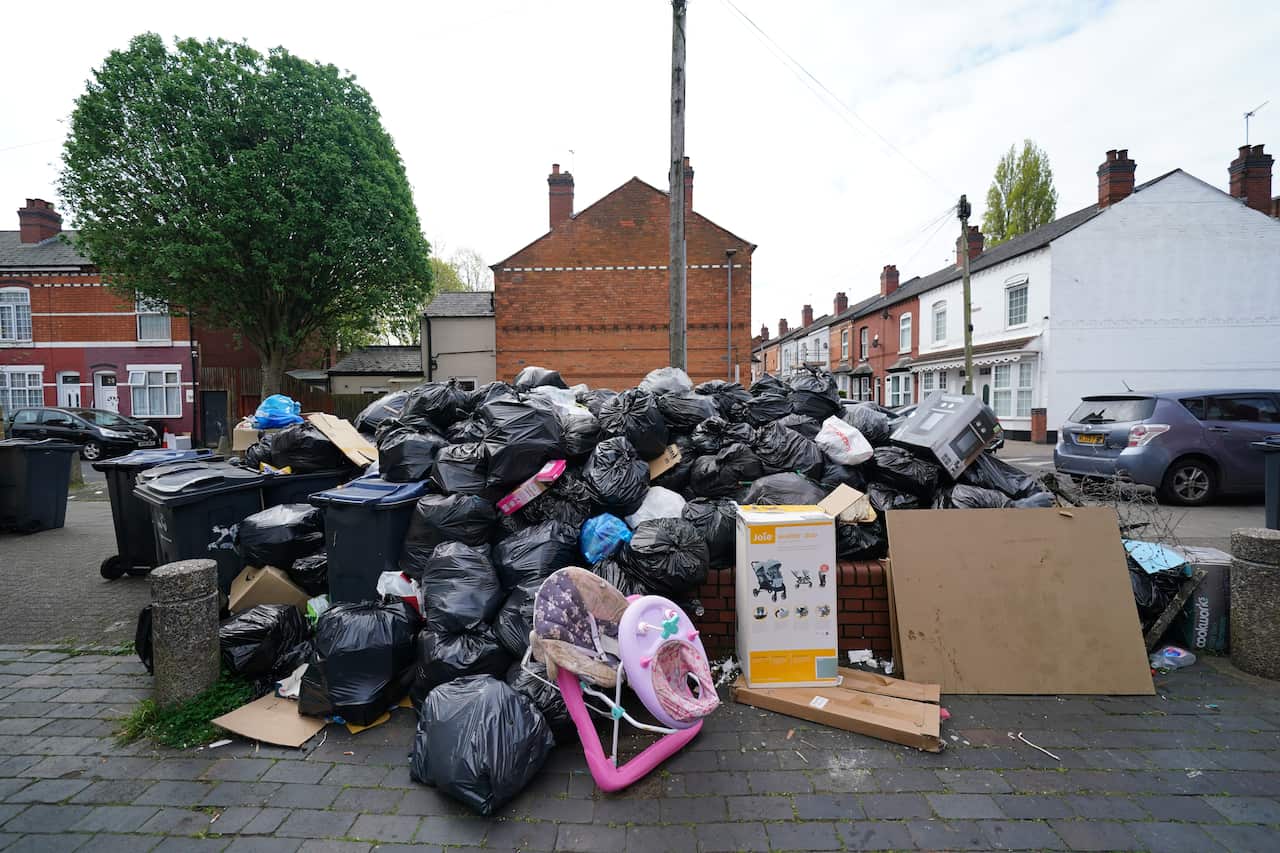 Black garbage bags pined up outside residential area.
