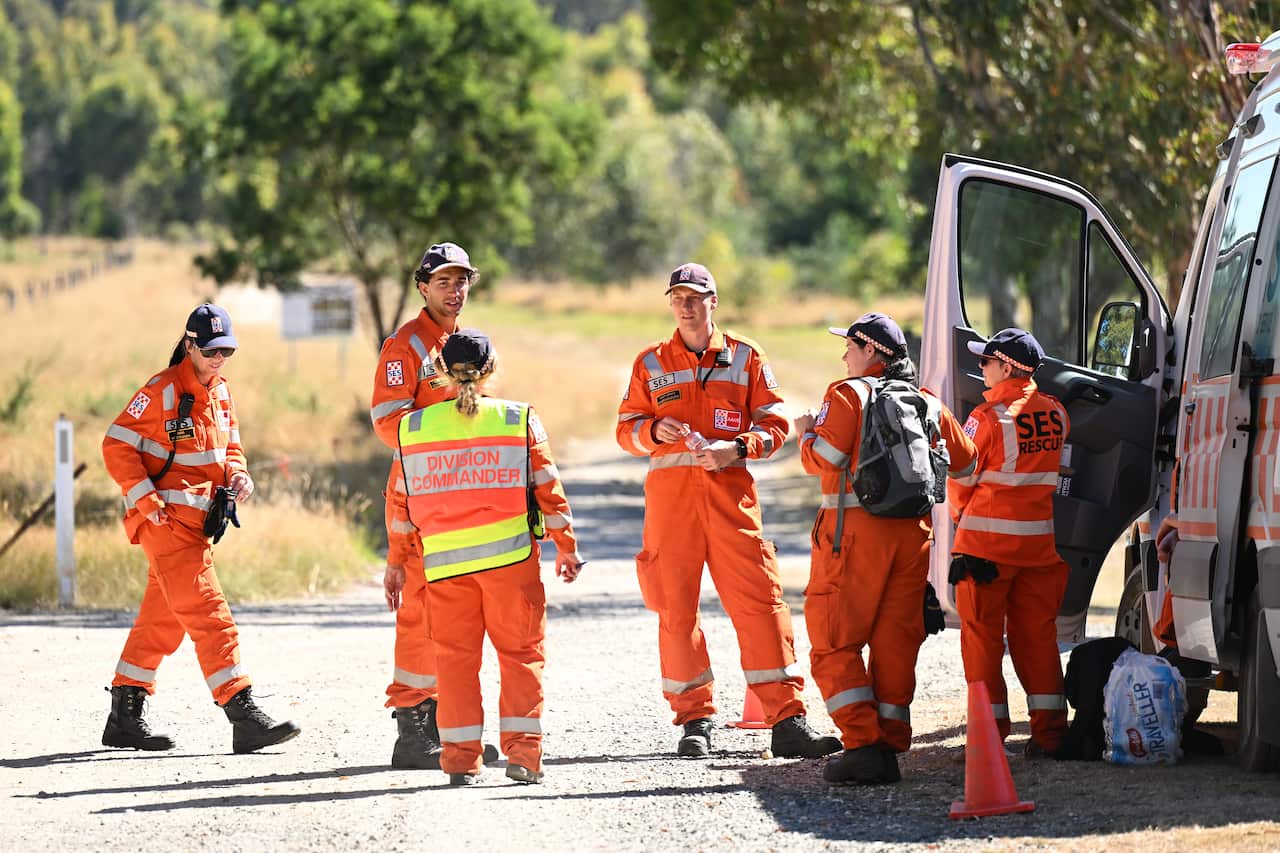 State Emergency Service workers speaking while standing next to a van.