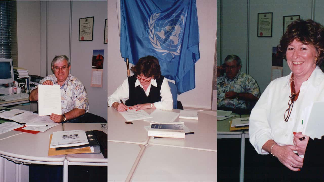 A three-way image showing a middle-aged man holding up a piece of paper in an office. The middle image shows a middle-aged woman with dark hair signing a piece of paper, with a UN flag draped on the wall behind her. The third image shows the woman and the man in the room together. The man is in the background, in shadow, while the woman is in the foreground, smiling.