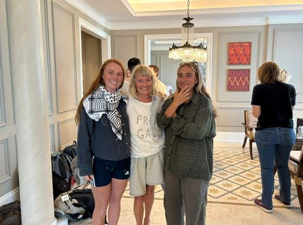 A woman smiling in between her two daughters