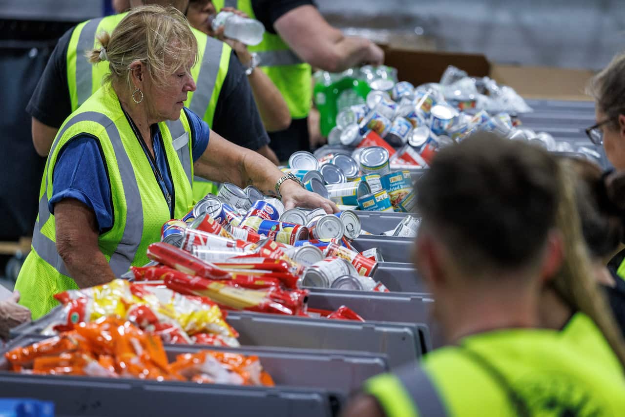 Volunteers in hi vis jackets are sorting aid into boxes.