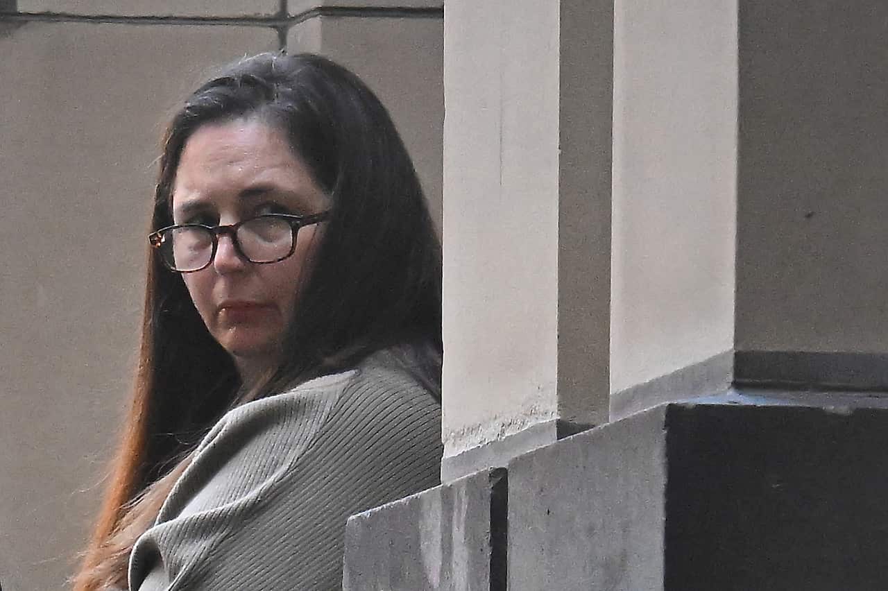 A woman in long brown hair wearing glasses