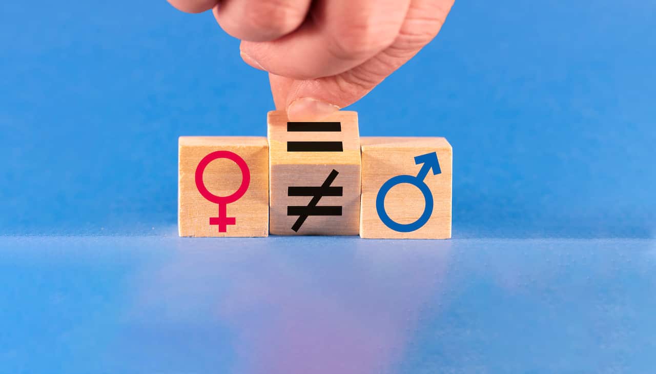 Concept of gender equality. A hand changes an unequal sign to an equal sign between male and female symbols.