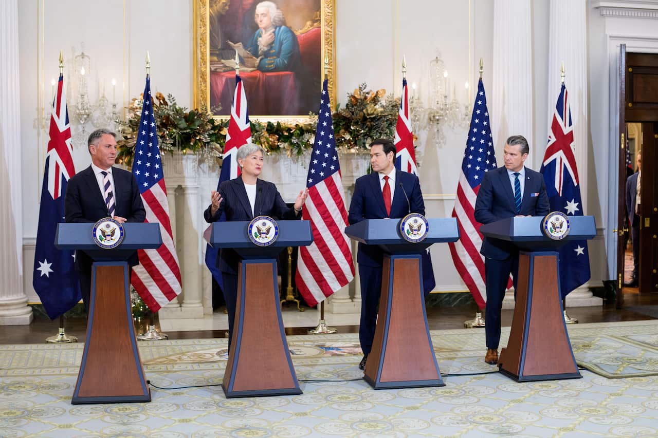 Richard Marles, Penny Wong, Marco Rubio and Pete Hegseth standing at podiums in a joint media conference in Washington DC.