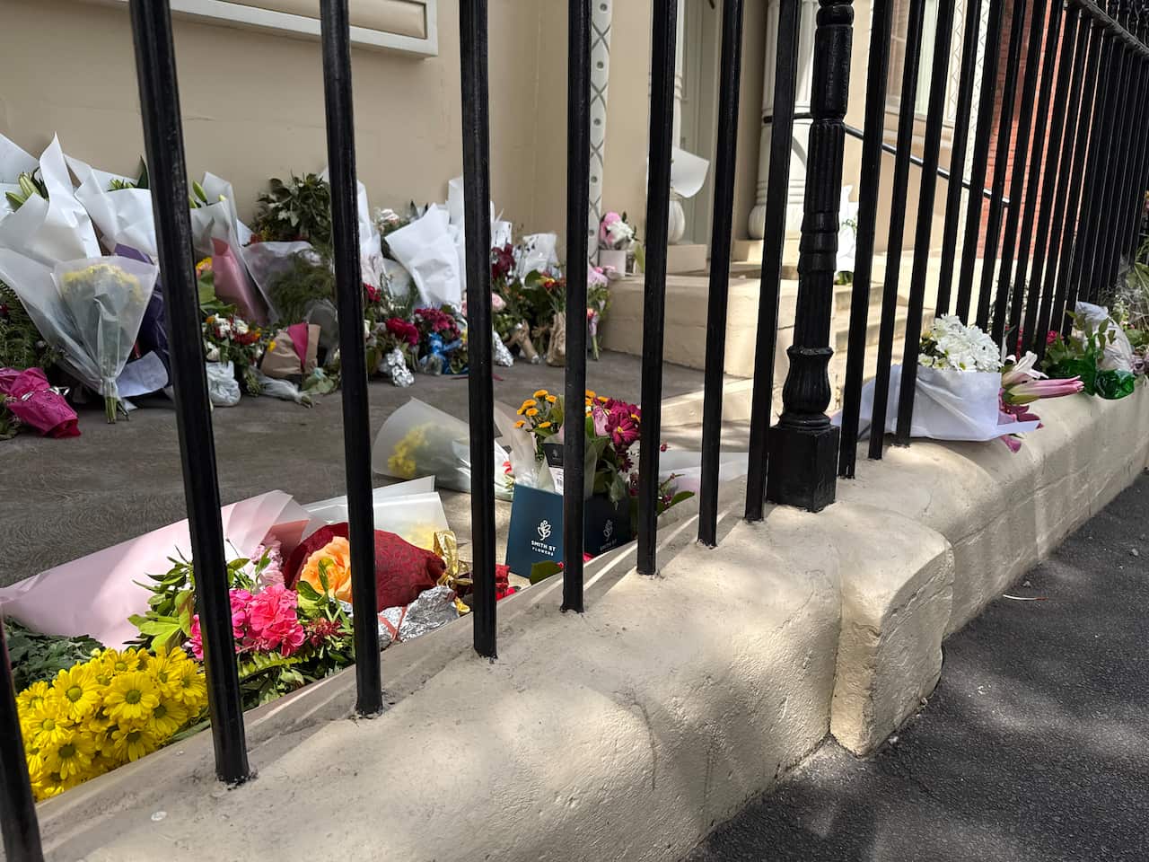 Bouquet of flowers behind an iron fence.
