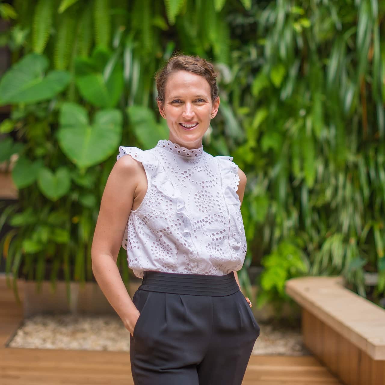 A woman smiling for a photo outside. 