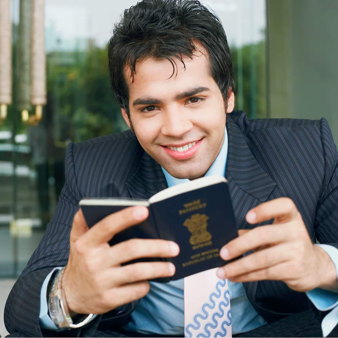 Portrait of a businessman holding a passport and smiling