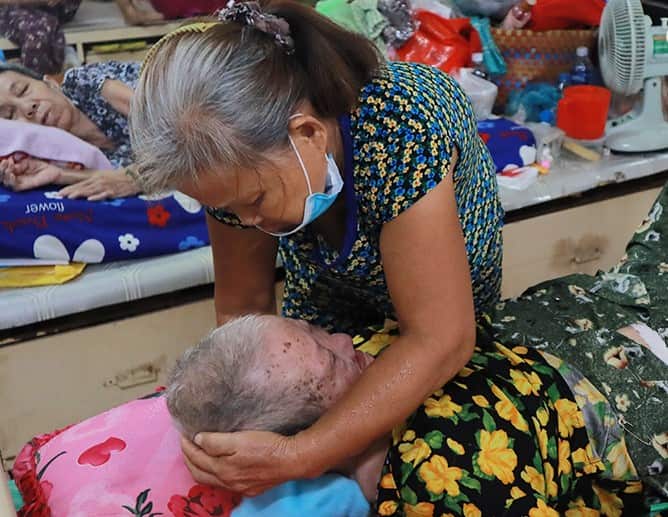 Thiện n guyện viên chăm sóc một cụ bà