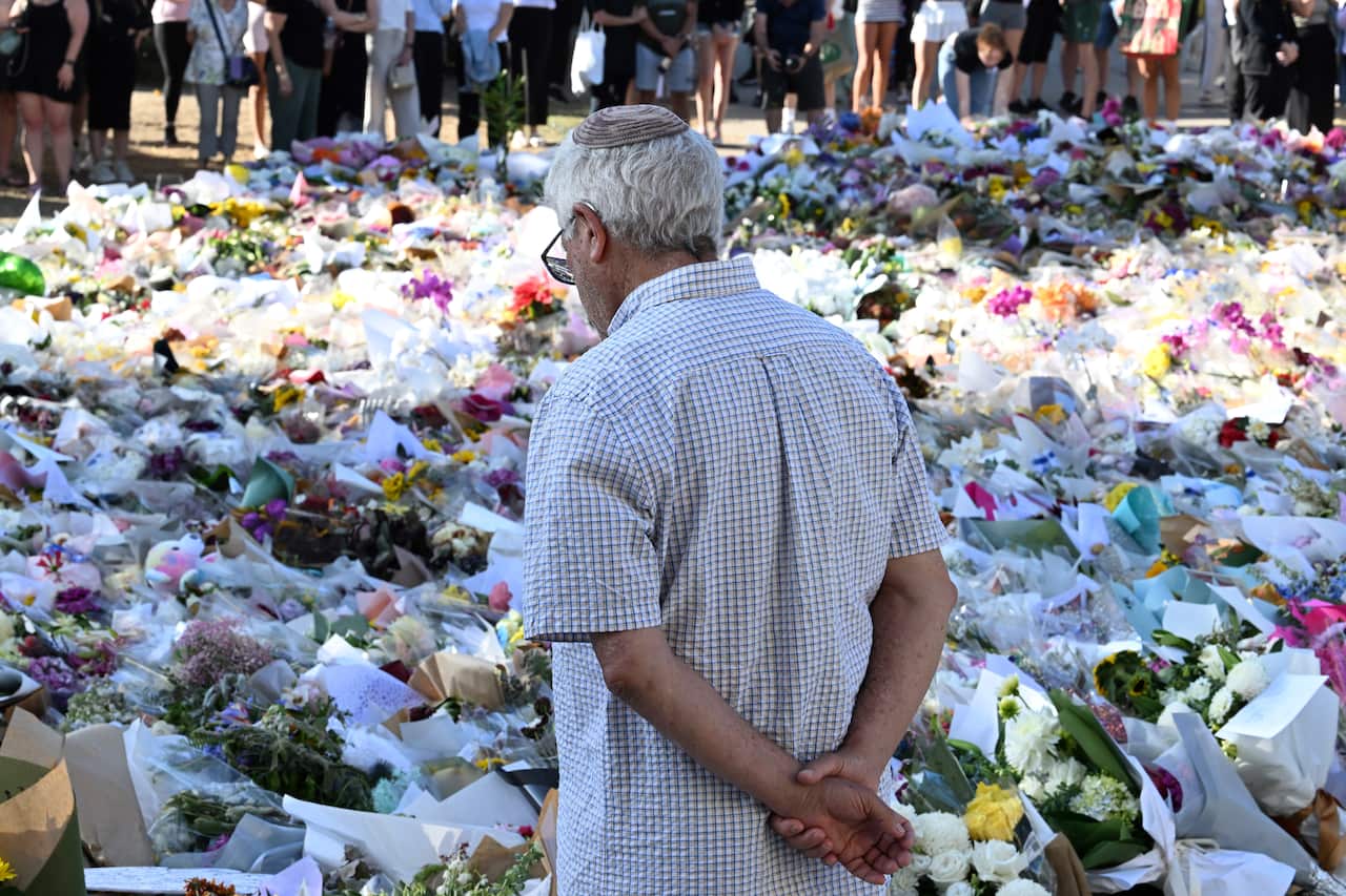A man standing in front of rows of flower bouquets on the ground.