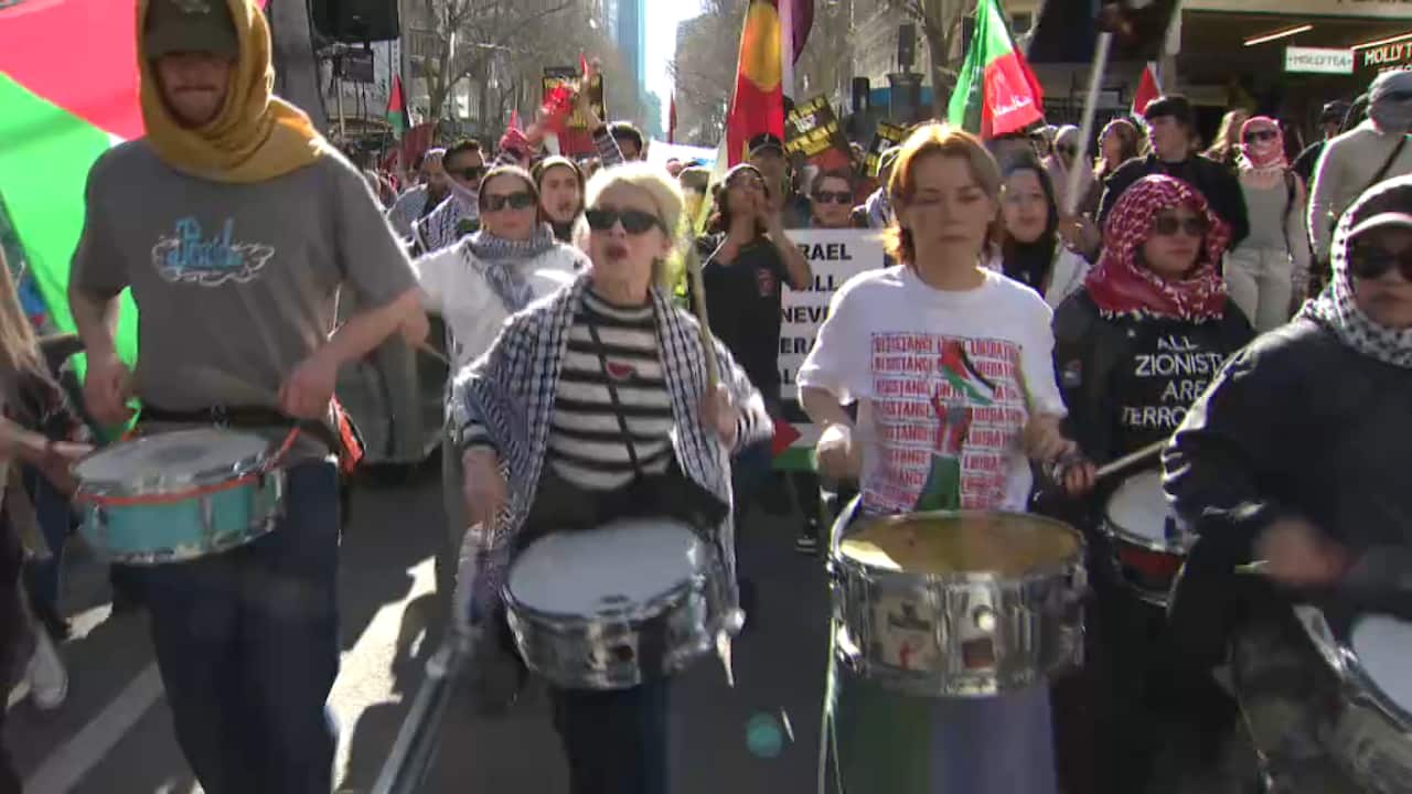 Un grupo de personas que tocan en la parte delantera de una marcha de protesta. 