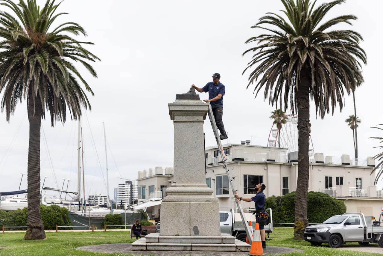 Council workers remove the remnants of a statue.