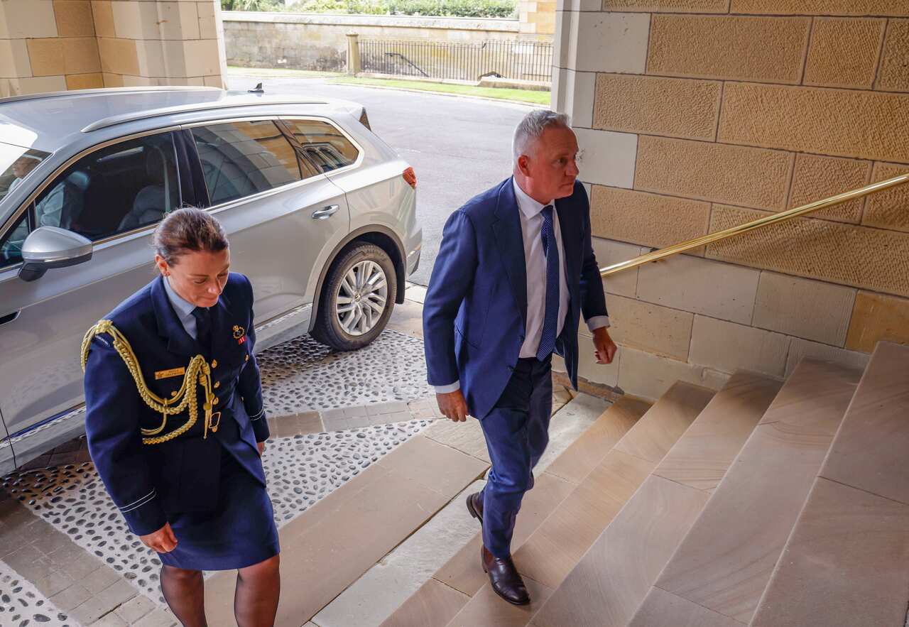 Tasmanian Premier Jeremy Rockliff walking up the steps at Government House in Hobart, with a woman in military style dress.