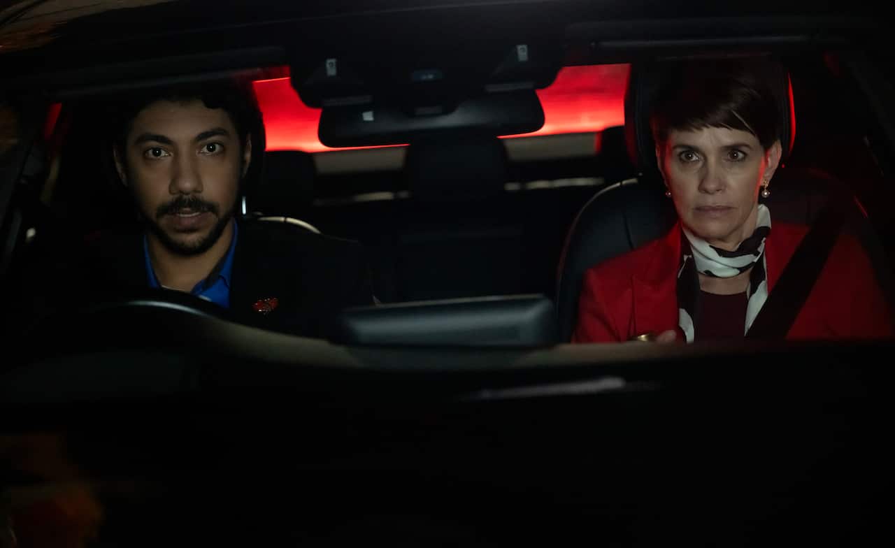 Two people in a car driving at night.