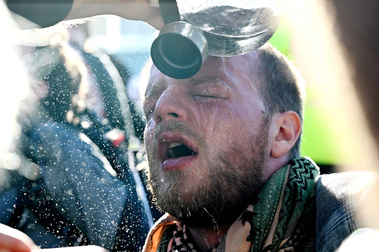 A protester washes his eyes out after being pepper sprayed by police