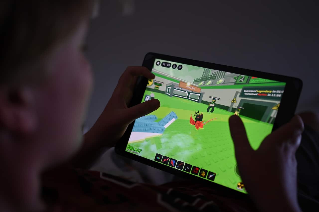 A 12-year-old boy plays a Roblox game on his device in Sydney.