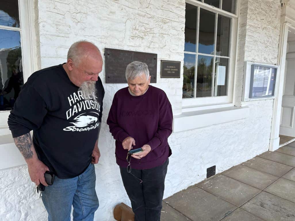 Two people are looking at a phone.