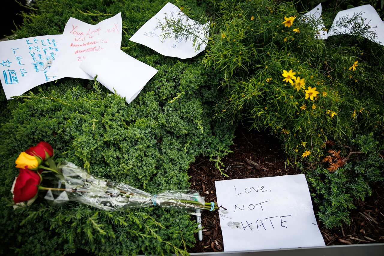 A pile of flowers and greenery and condolence notes