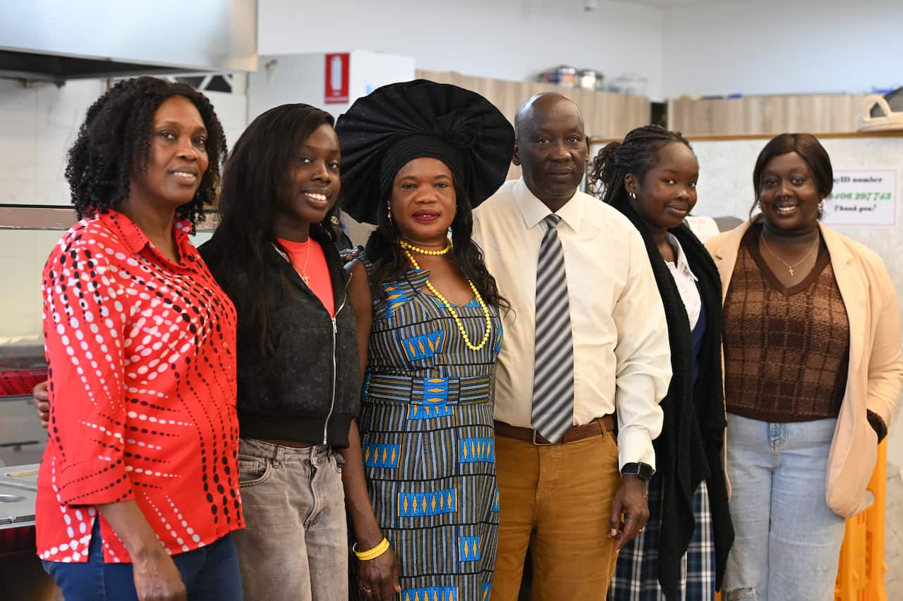 Family members, including four women and one men, smile for a photo