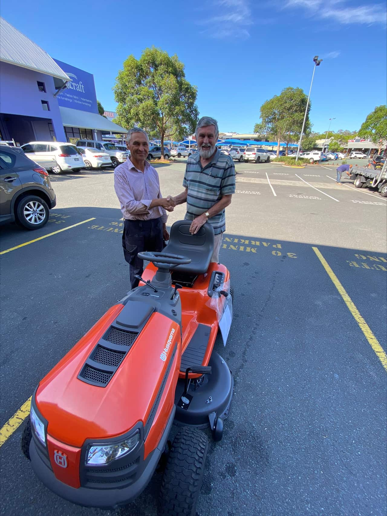 David Field (left) shaking hands with a Ukrainian refugee (right) who just received a ride-on lawn mower funded by the URSC.jpeg