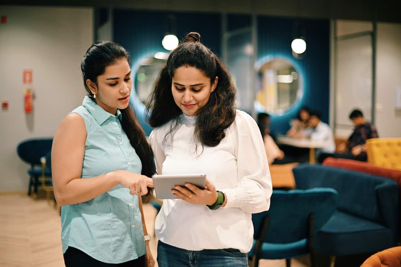 Two women standing and discussing in the co-working office