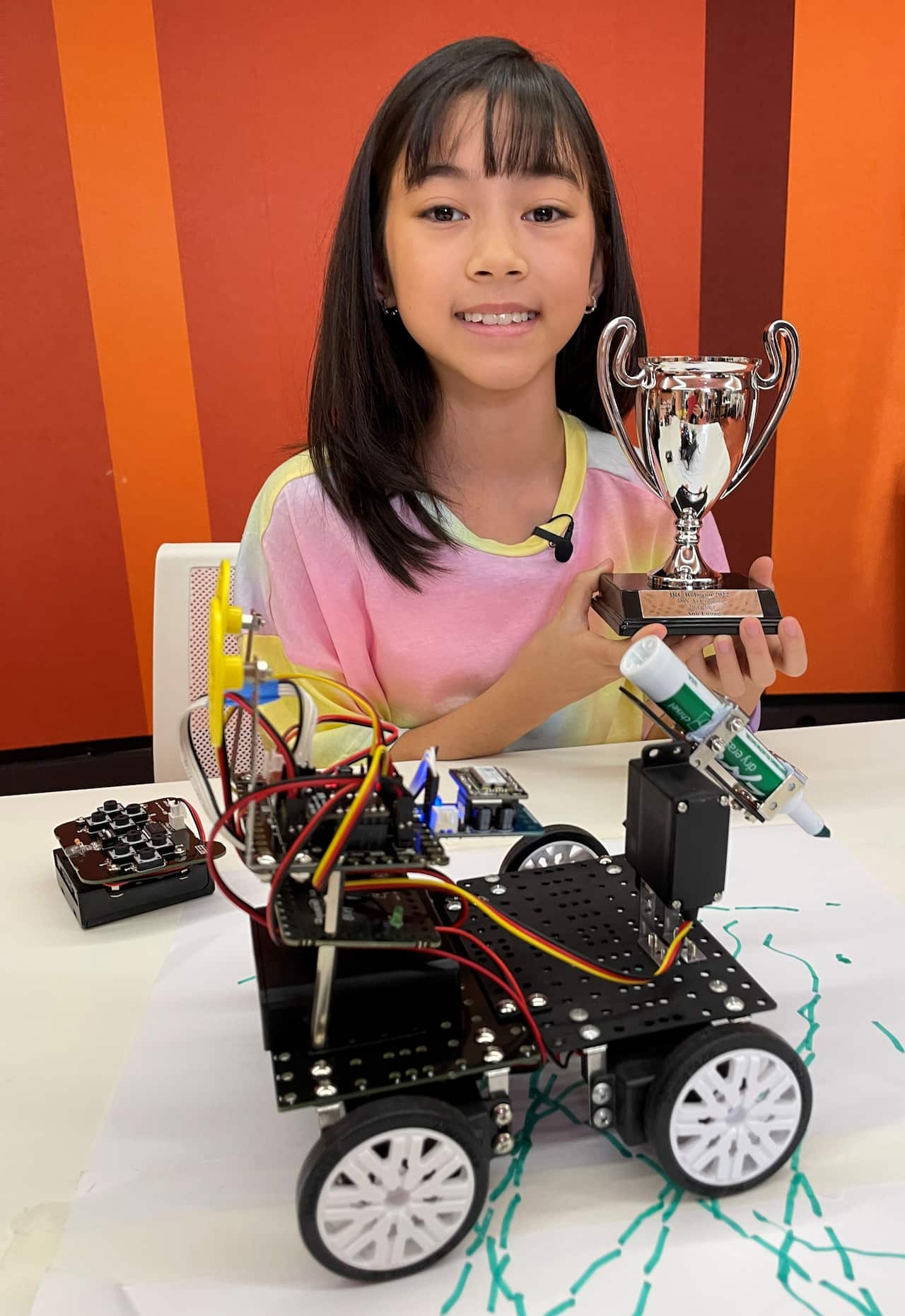 Anh Luong with her 'art bot' and holding a trophy.