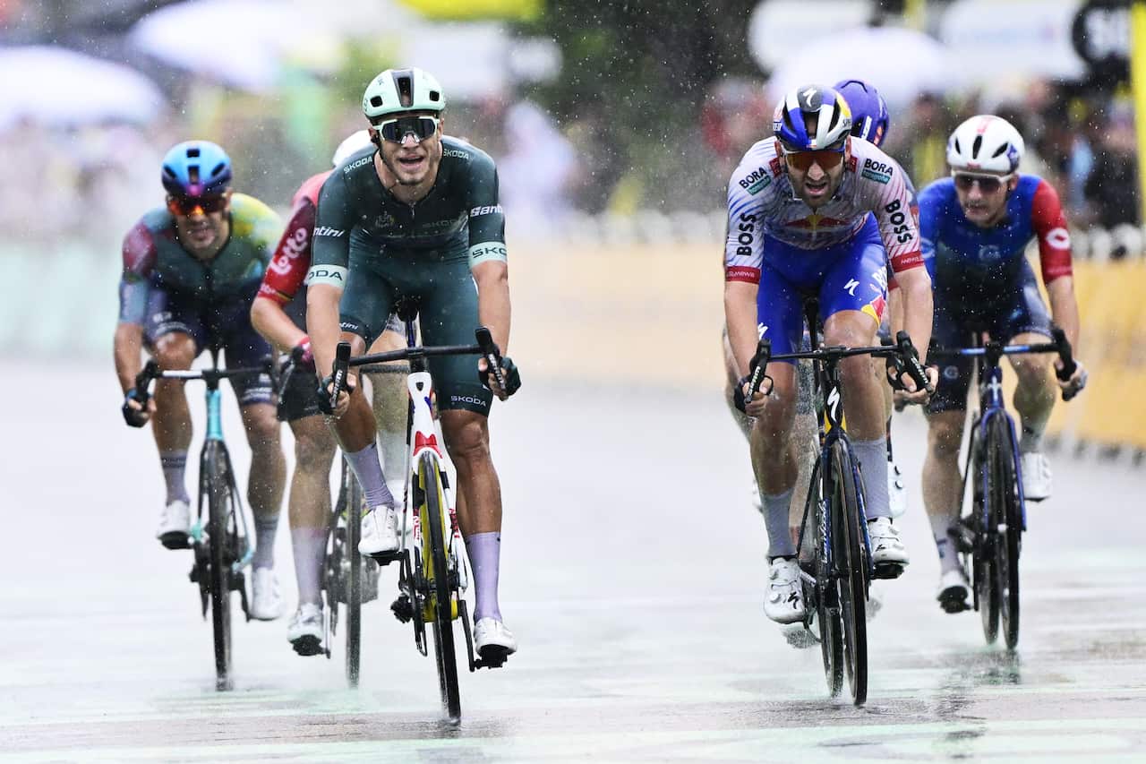 A group of cyclists riding in the rain
